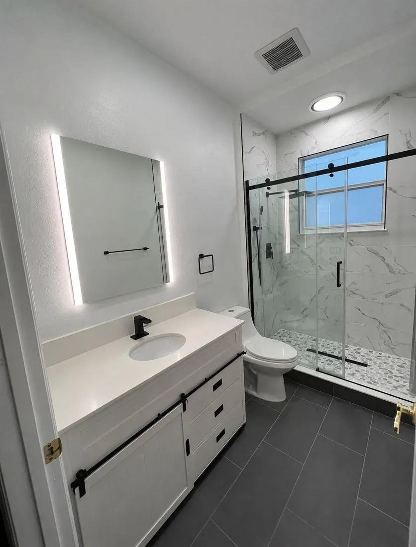 Baño remodelado con acabados modernos